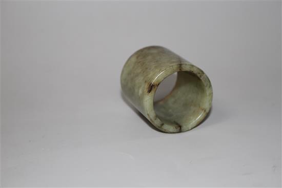 A Chinese celadon and brown jade cylinder, probably archaic, H. 4.6cm